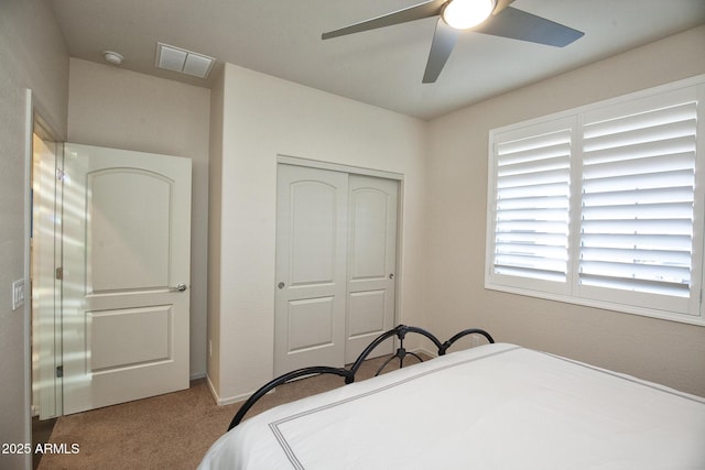 carpeted bedroom with ceiling fan and a closet