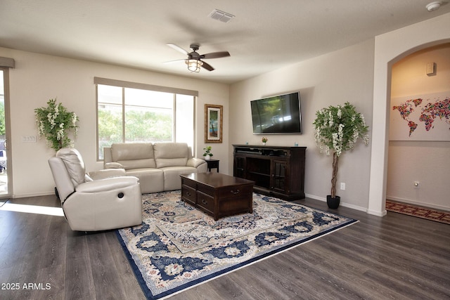 living room with ceiling fan and dark hardwood / wood-style flooring