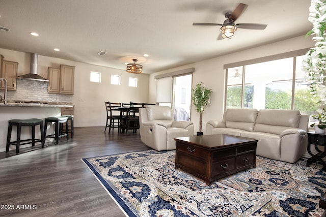 living room featuring dark wood-type flooring and ceiling fan