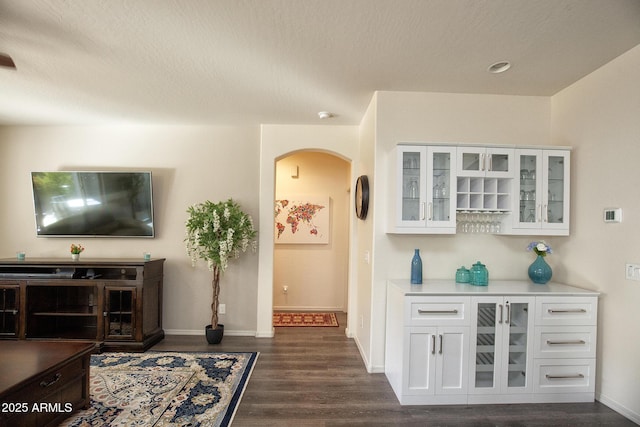 bar featuring white cabinetry and dark hardwood / wood-style floors