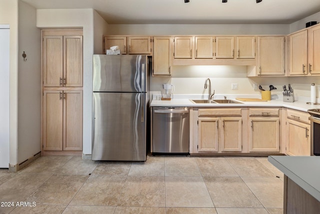 kitchen featuring light brown cabinetry, stainless steel appliances, and sink