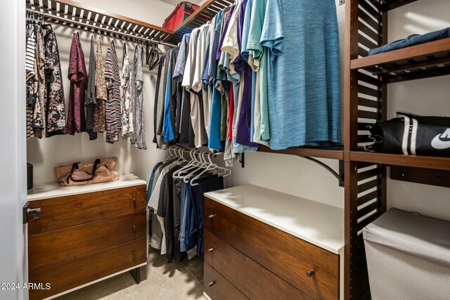 walk in closet with light tile patterned floors