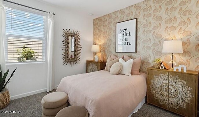 bedroom featuring dark carpet, baseboards, and wallpapered walls