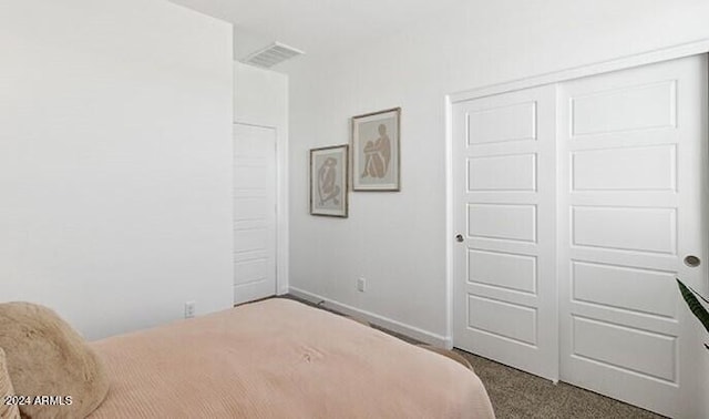 bedroom featuring dark colored carpet, a closet, visible vents, and baseboards