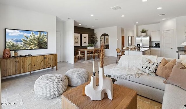 living room with visible vents, arched walkways, and recessed lighting