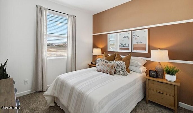 bedroom with baseboards and dark carpet