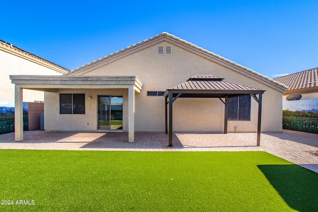 back of house featuring a patio and a lawn