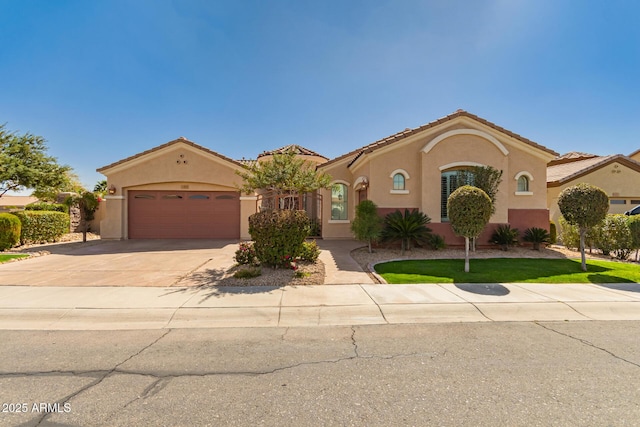 mediterranean / spanish home with a garage, driveway, a tiled roof, and stucco siding