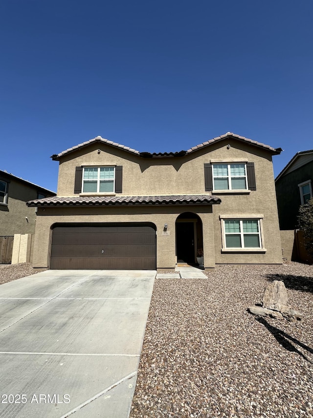 mediterranean / spanish-style home featuring stucco siding, a garage, and concrete driveway