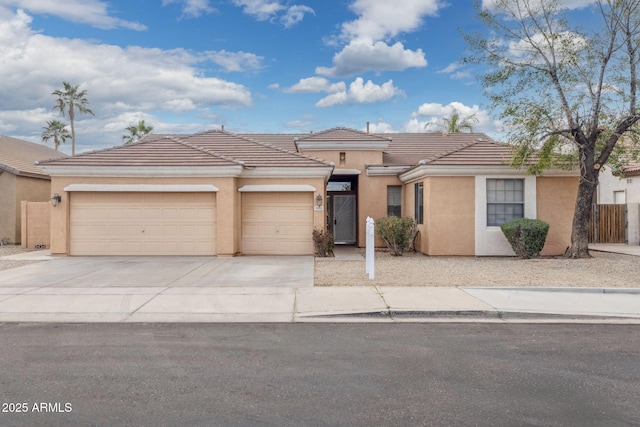 view of front facade featuring stucco siding, driveway, a tile roof, fence, and an attached garage