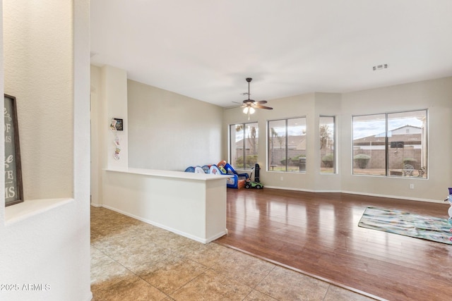 kitchen with visible vents, a ceiling fan, baseboards, and wood finished floors