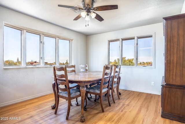 dining room with a ceiling fan, light wood-style flooring, and baseboards