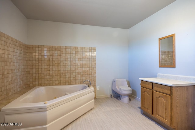 full bathroom featuring baseboards, toilet, a tub with jets, wood finished floors, and vanity