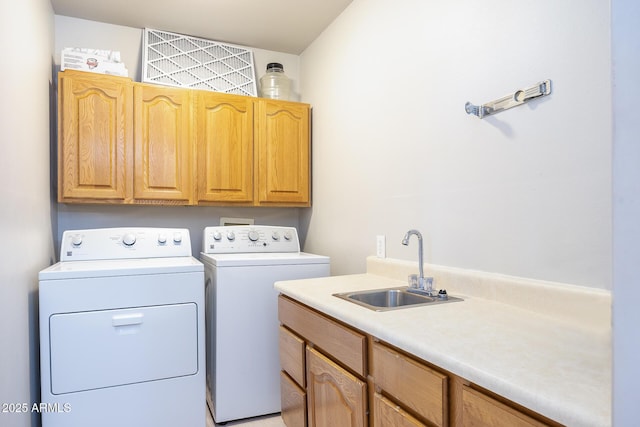 washroom featuring cabinet space, a sink, and washing machine and clothes dryer