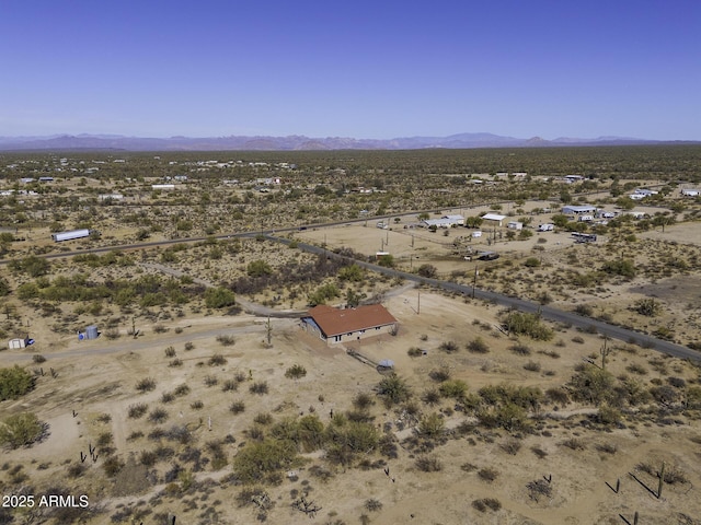 drone / aerial view featuring a mountain view and view of desert