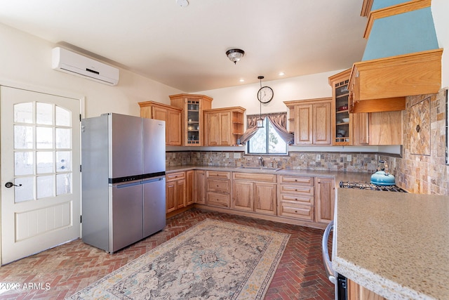 kitchen featuring premium range hood, tasteful backsplash, an AC wall unit, stainless steel refrigerator, and hanging light fixtures