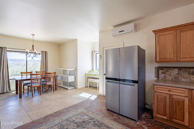 kitchen featuring a wall unit AC, an inviting chandelier, a mountain view, stainless steel refrigerator, and hanging light fixtures