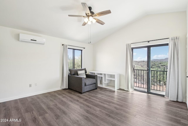 unfurnished room featuring a wealth of natural light, dark hardwood / wood-style floors, a wall unit AC, and vaulted ceiling