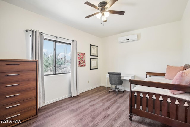 bedroom with ceiling fan, wood-type flooring, and a wall mounted air conditioner