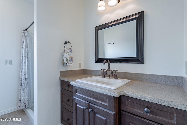 bathroom featuring tile patterned flooring, vanity, and walk in shower