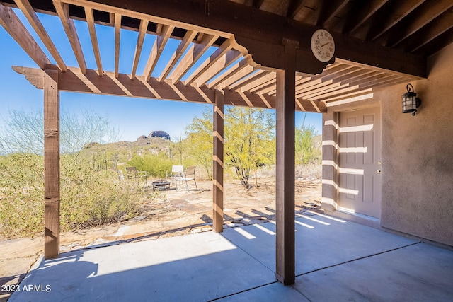 view of patio with a mountain view, a pergola, and a fire pit