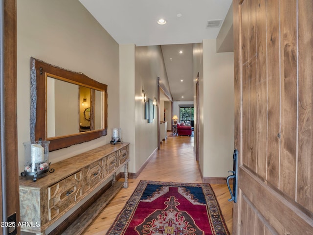 corridor with light hardwood / wood-style flooring