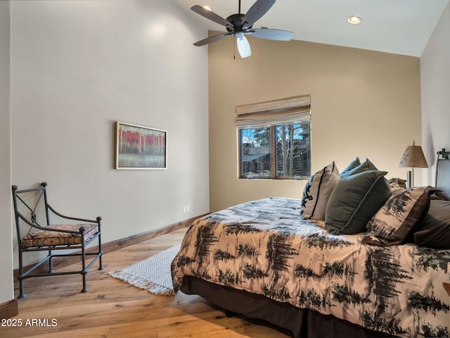 bedroom featuring high vaulted ceiling and light hardwood / wood-style floors