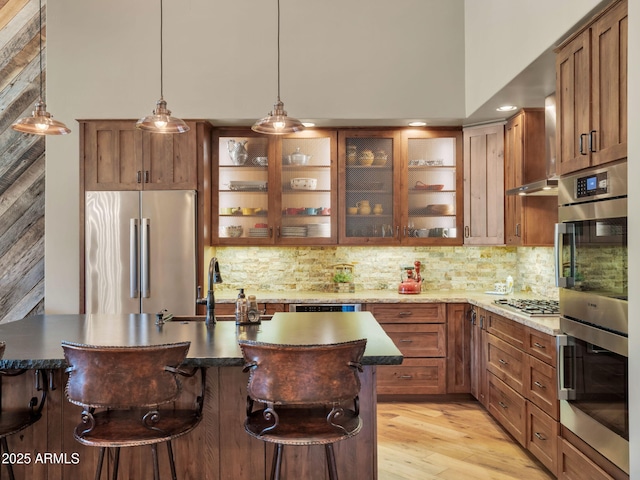 kitchen featuring appliances with stainless steel finishes, sink, a breakfast bar area, decorative backsplash, and hanging light fixtures