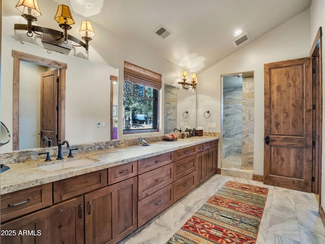 bathroom featuring vanity, vaulted ceiling, and a tile shower