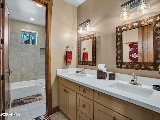 full bathroom featuring tiled shower / bath combo, vanity, and toilet