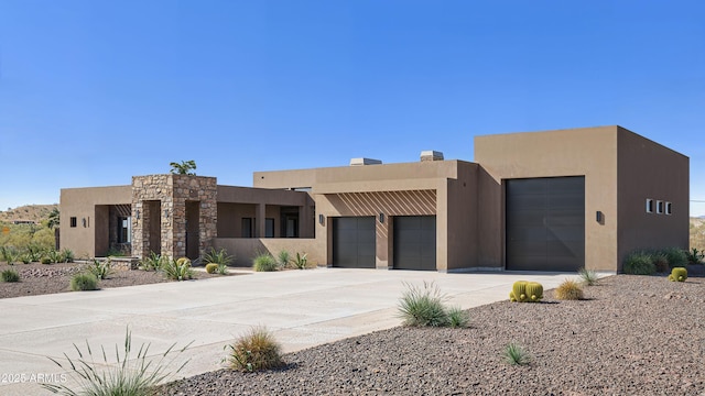 southwest-style home with an attached garage, stucco siding, and concrete driveway