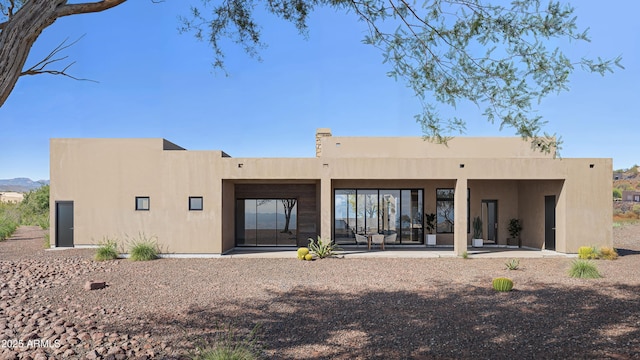 back of house with a patio and stucco siding
