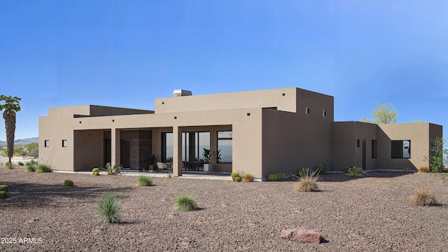rear view of property featuring stucco siding