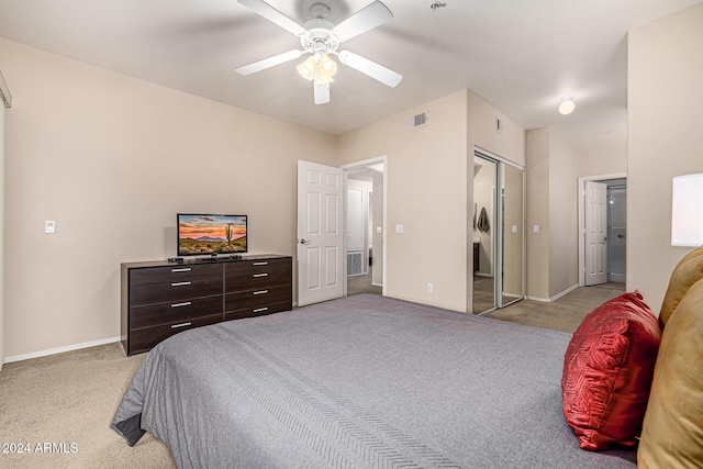 carpeted bedroom with ceiling fan and a closet