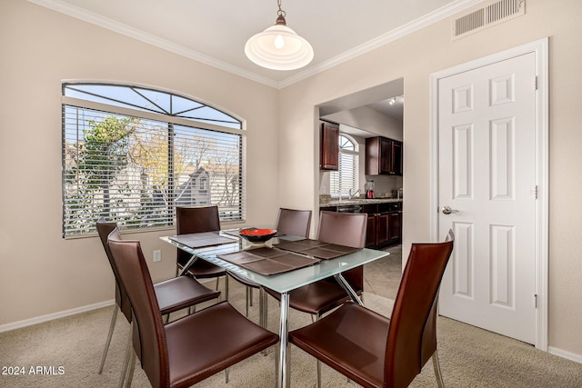 carpeted dining area with crown molding