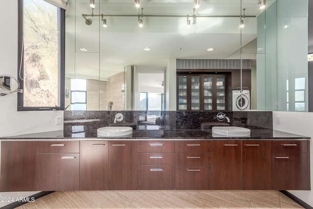 kitchen with plenty of natural light, dark stone countertops, and sink