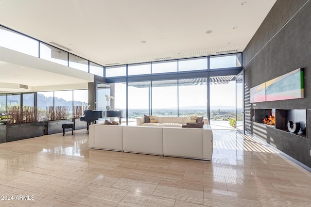 unfurnished living room featuring a mountain view, expansive windows, and a healthy amount of sunlight