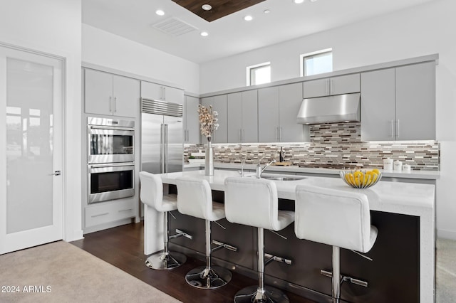 kitchen featuring a breakfast bar, appliances with stainless steel finishes, a kitchen island with sink, and sink