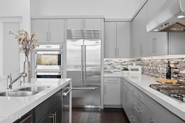 kitchen featuring sink, decorative backsplash, light stone countertops, appliances with stainless steel finishes, and extractor fan