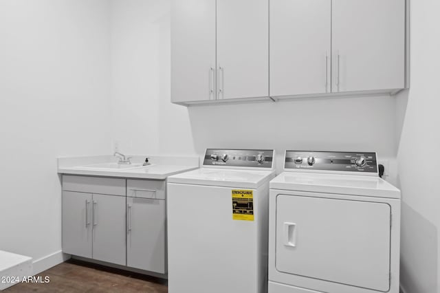 clothes washing area featuring separate washer and dryer, sink, cabinets, and dark hardwood / wood-style flooring