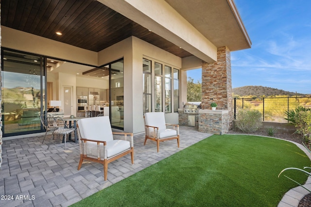 view of patio with a mountain view, area for grilling, and a grill