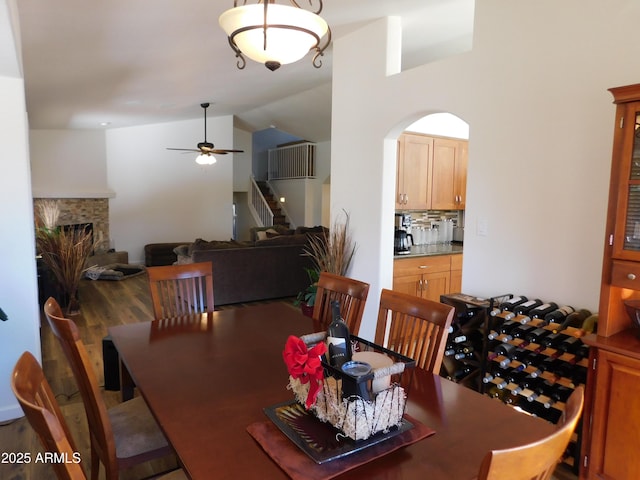 dining space featuring ceiling fan, dark wood-type flooring, and vaulted ceiling