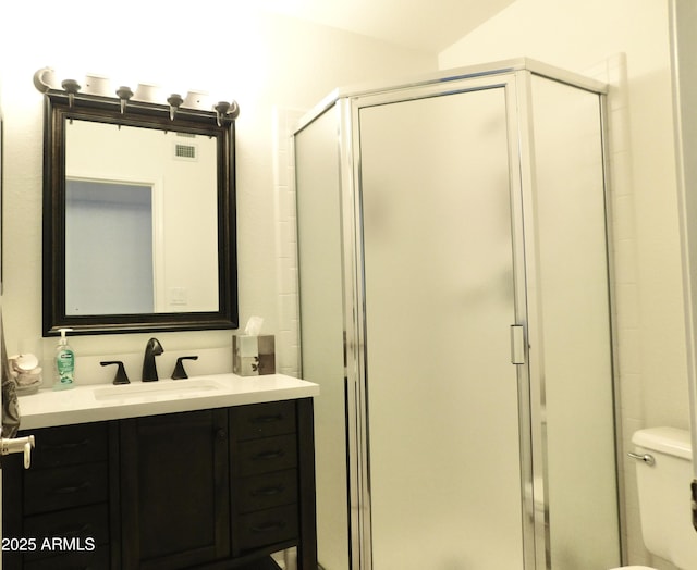 bathroom featuring vanity, toilet, and walk in shower