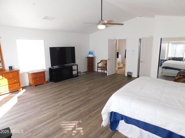 bedroom featuring dark hardwood / wood-style flooring, ensuite bathroom, vaulted ceiling, and ceiling fan