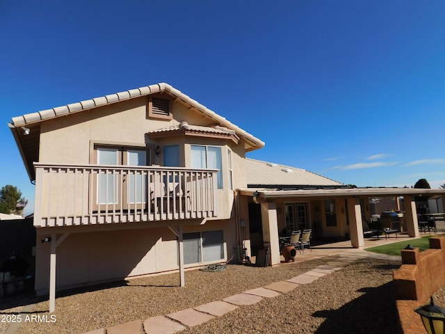 rear view of house featuring a balcony and a patio area