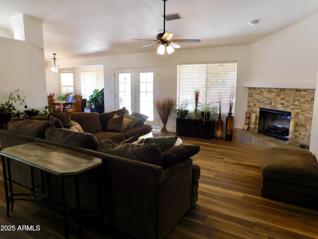 living room with a fireplace, ceiling fan, french doors, and dark wood-type flooring