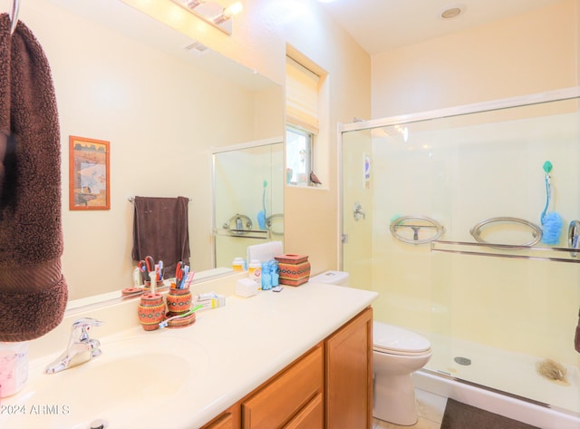 bathroom with tile patterned flooring, vanity, toilet, and a shower with shower door