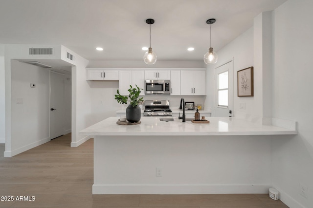 1051 E Millett Ave, Mesa, AZ 85204 - kitchen featuring stainless steel appliances, white cabinetry, light countertops, light wood-style floors, and recessed lighting