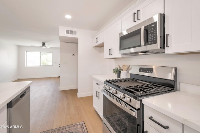 1051 E Millett Ave, Mesa, AZ 85204 - kitchen with stainless steel appliances, light countertops, light wood-type flooring, ceiling fan, and white cabinets