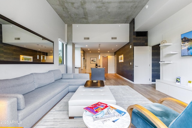 living room featuring a high ceiling and light wood-type flooring